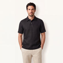 Model wearing obsidian black linen polo shirt