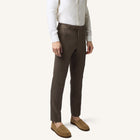 Model wearing Rizvol dried fig brown linen trousers, front view