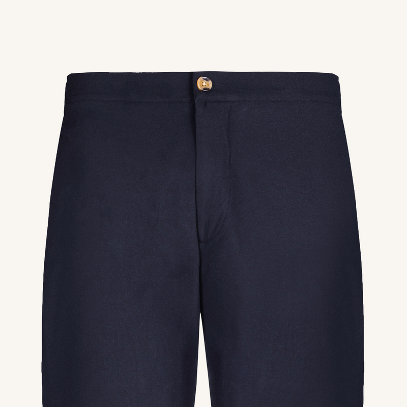 Navy blue pants with a button on a light gray background